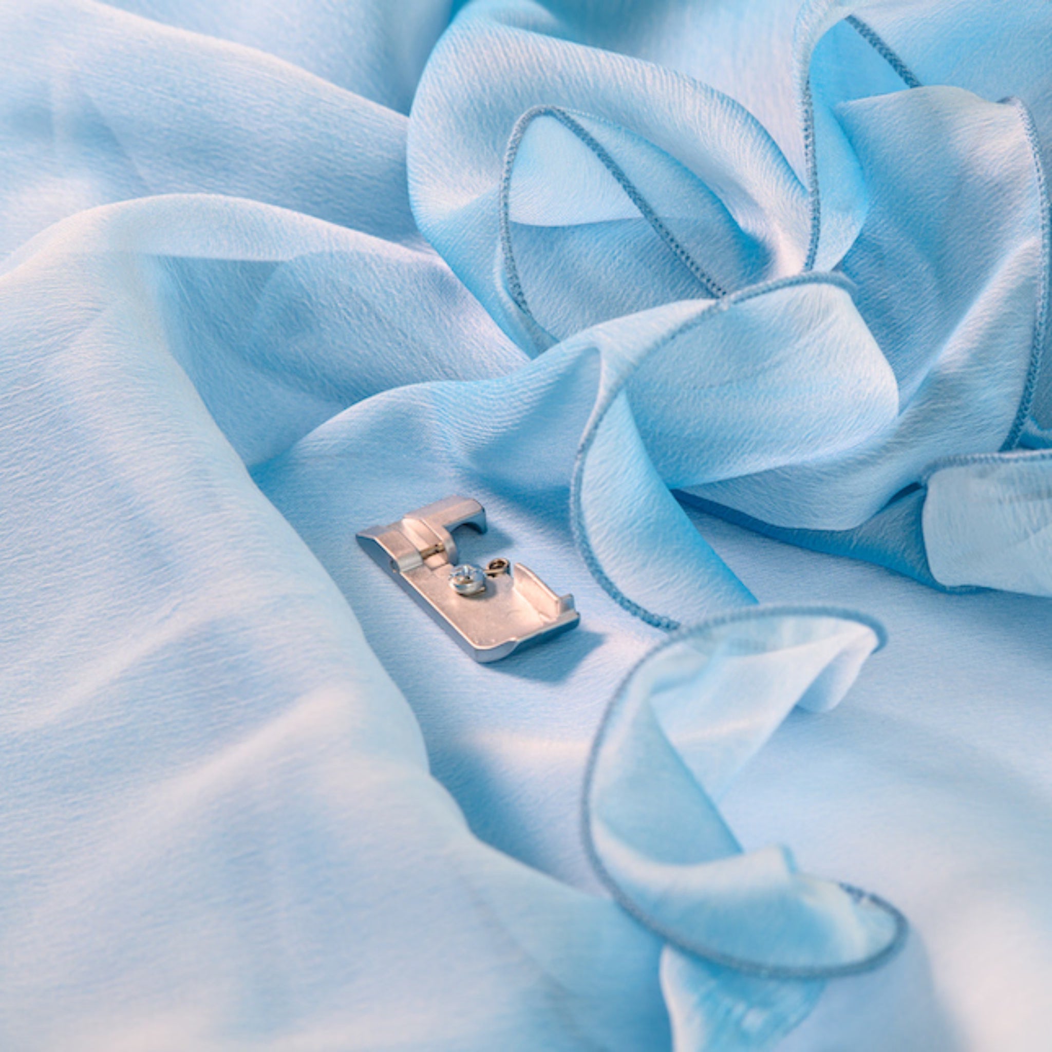 Small silver object on a textured blue fabric surface