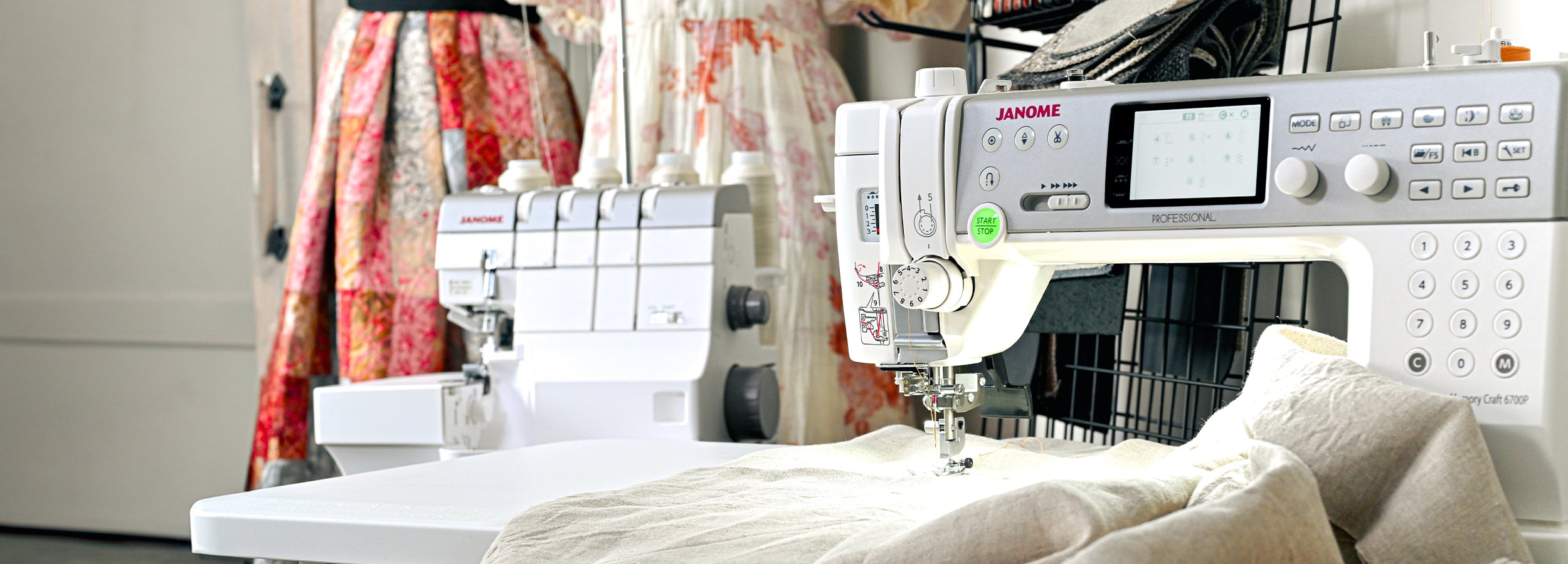 Janome symaskin og overlockmaskin med kjoler i bakgrunn